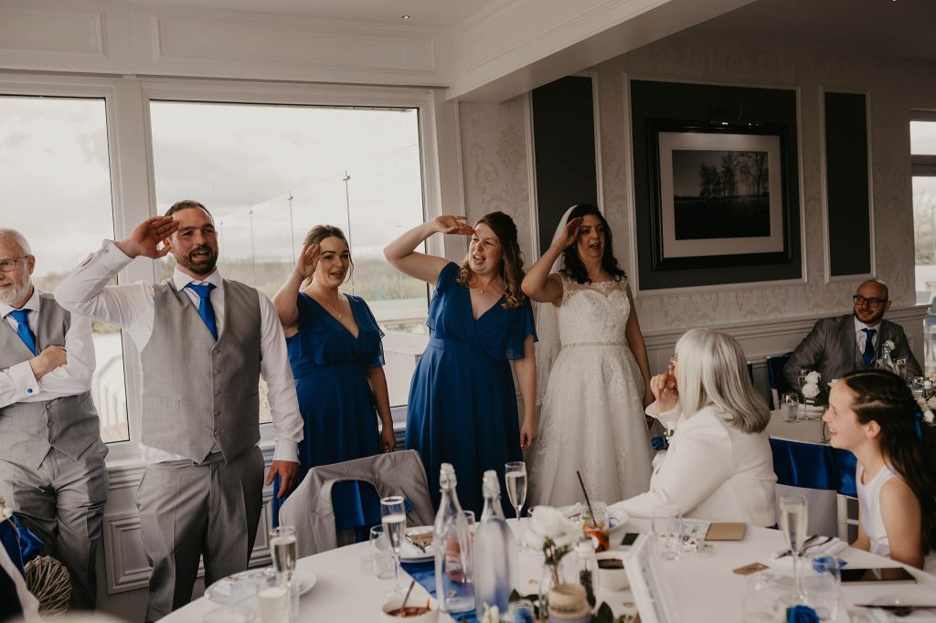 bride and her siblings doing a penguin dance for fun by nikki terra who loves photographing quirky wedding details in Hampshire
