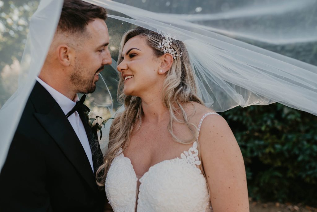 bride and groom photographed outside at Newtown House in Hayling Island by nikki terra who loves photographing quirky wedding details in Hampshire